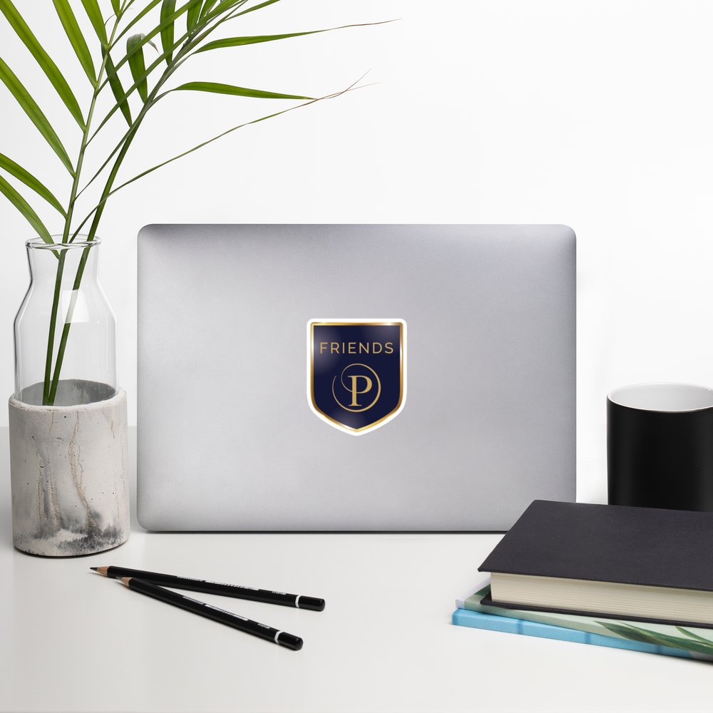 Laptop with 'Friends' logo on a desk with a plant, notebook, and pencils.